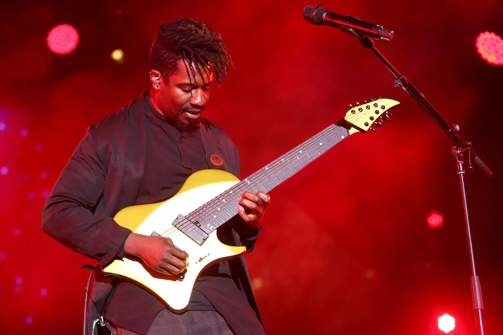 Tosin Abassi playing guitar on stage